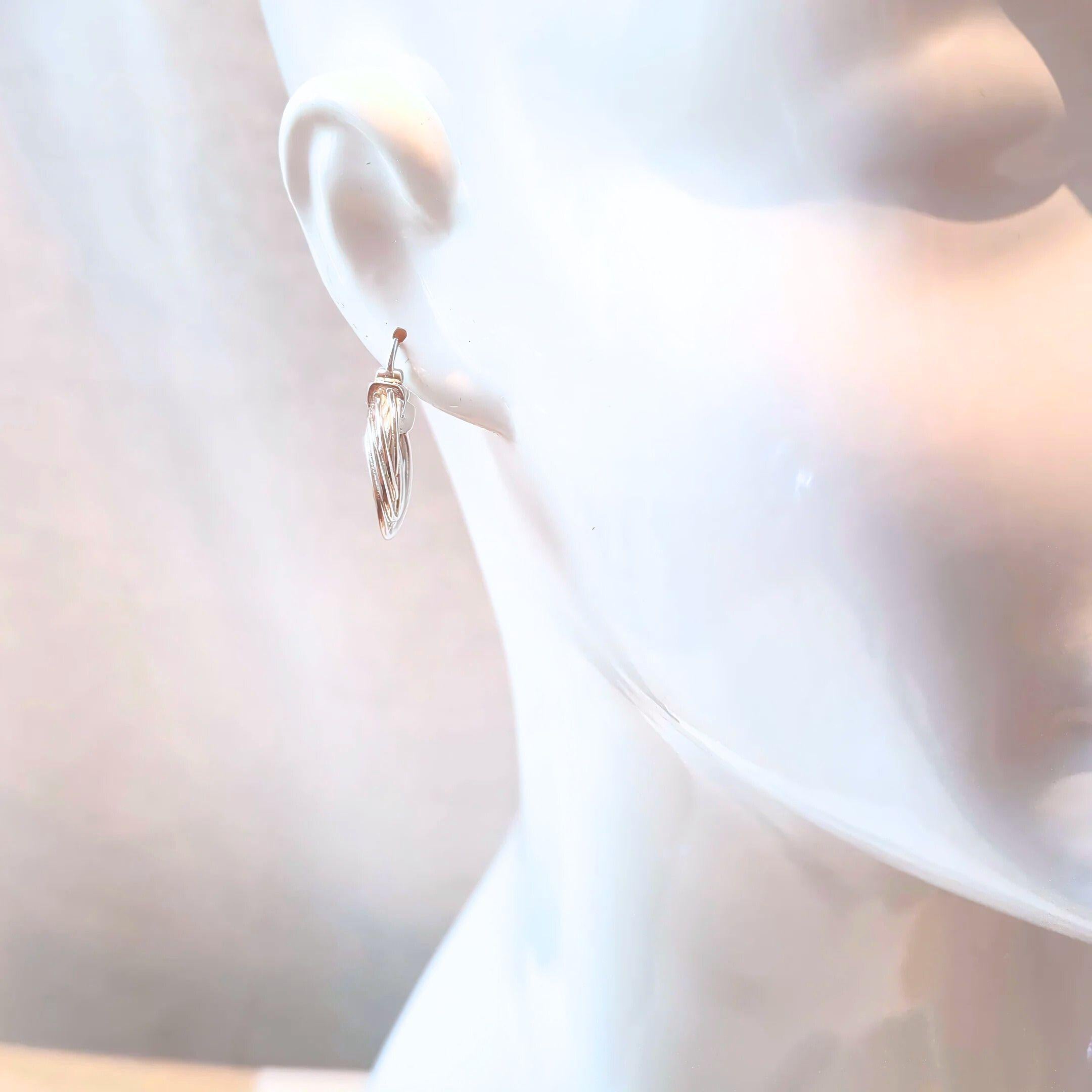 orbit hoop earrings in silver on white mannequin behind white background