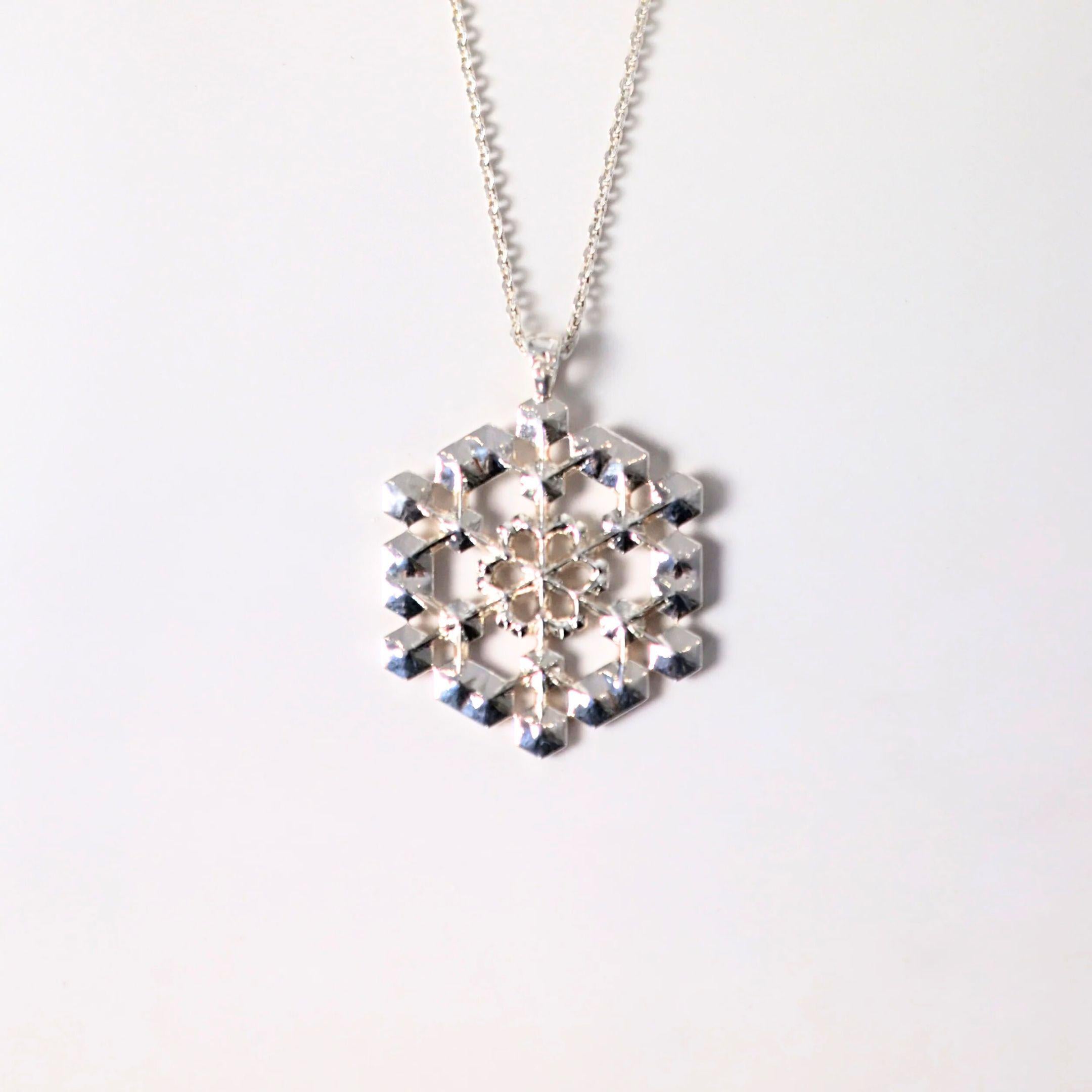 a close up of a sterling silver snowflake pendant
