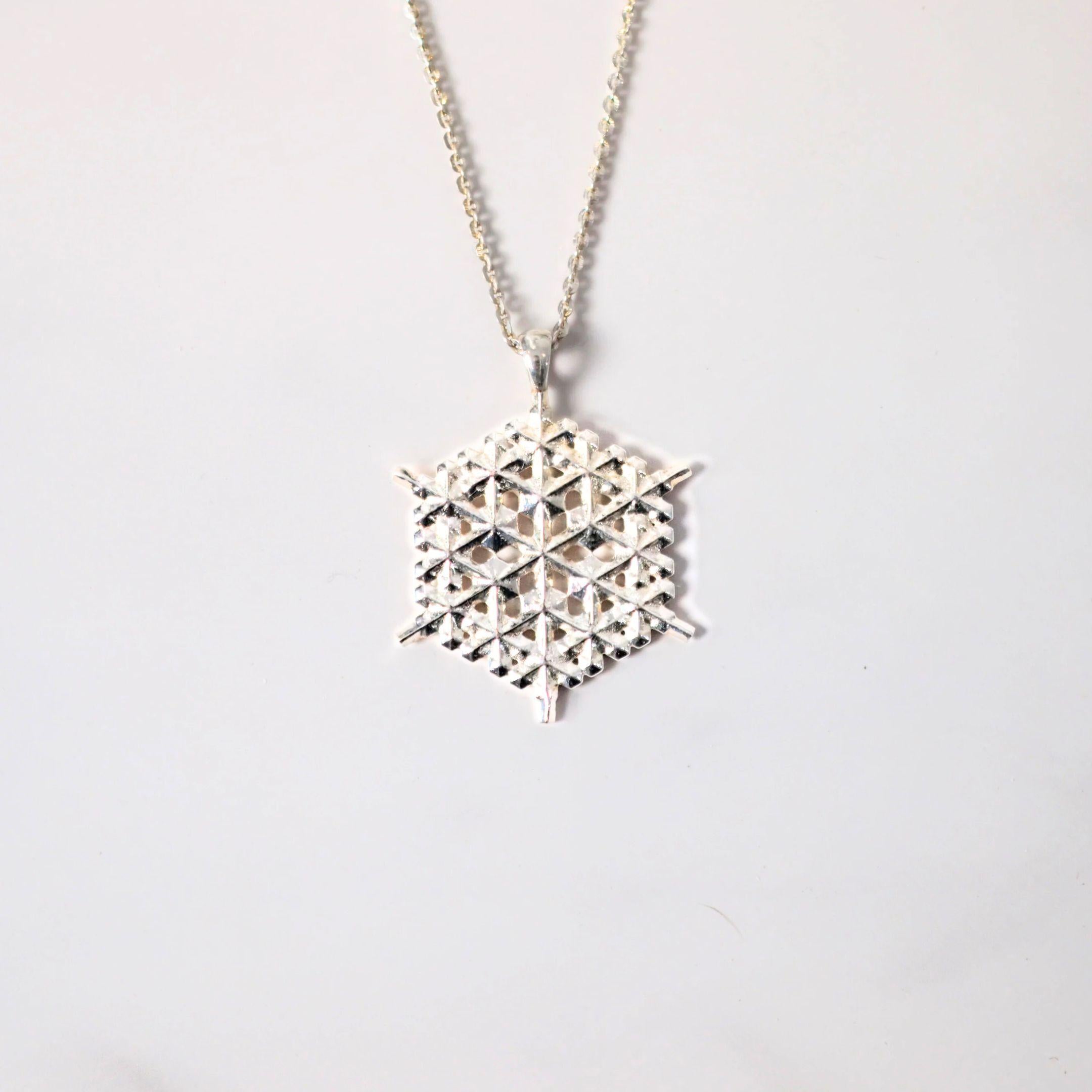 a close up of a sterling silver pendant on a white background