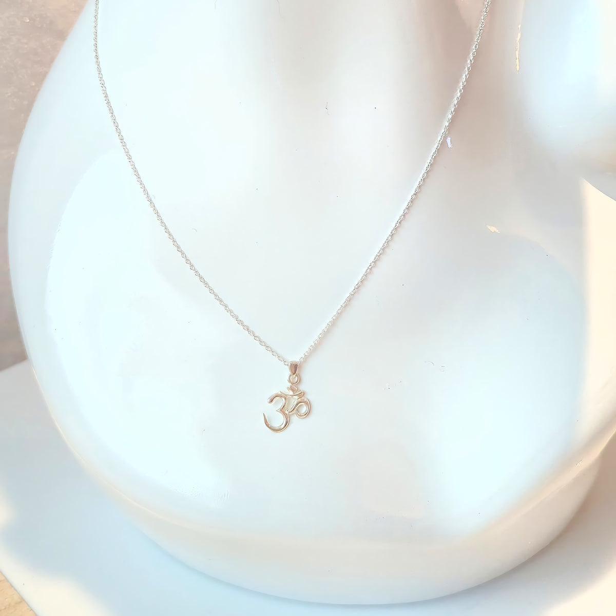 Silver Classic Om pendant on a chain on a white mannequin