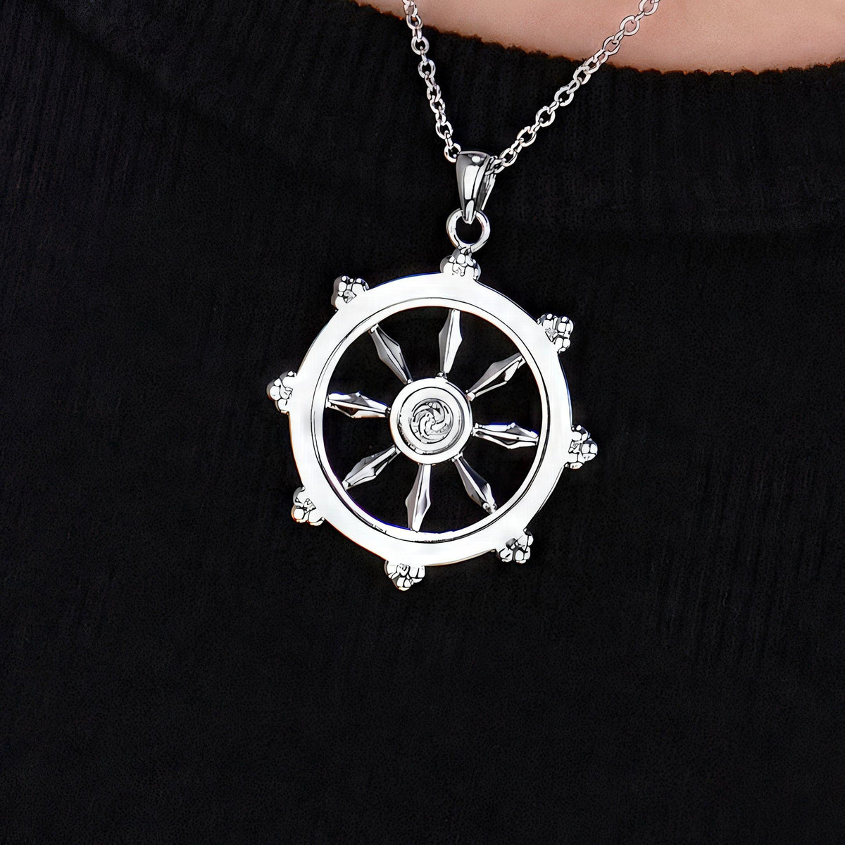Dharmachakra Pendant in sterling silver, a Buddhist dharma wheel necklace shown on a black blouse, by Baroque++