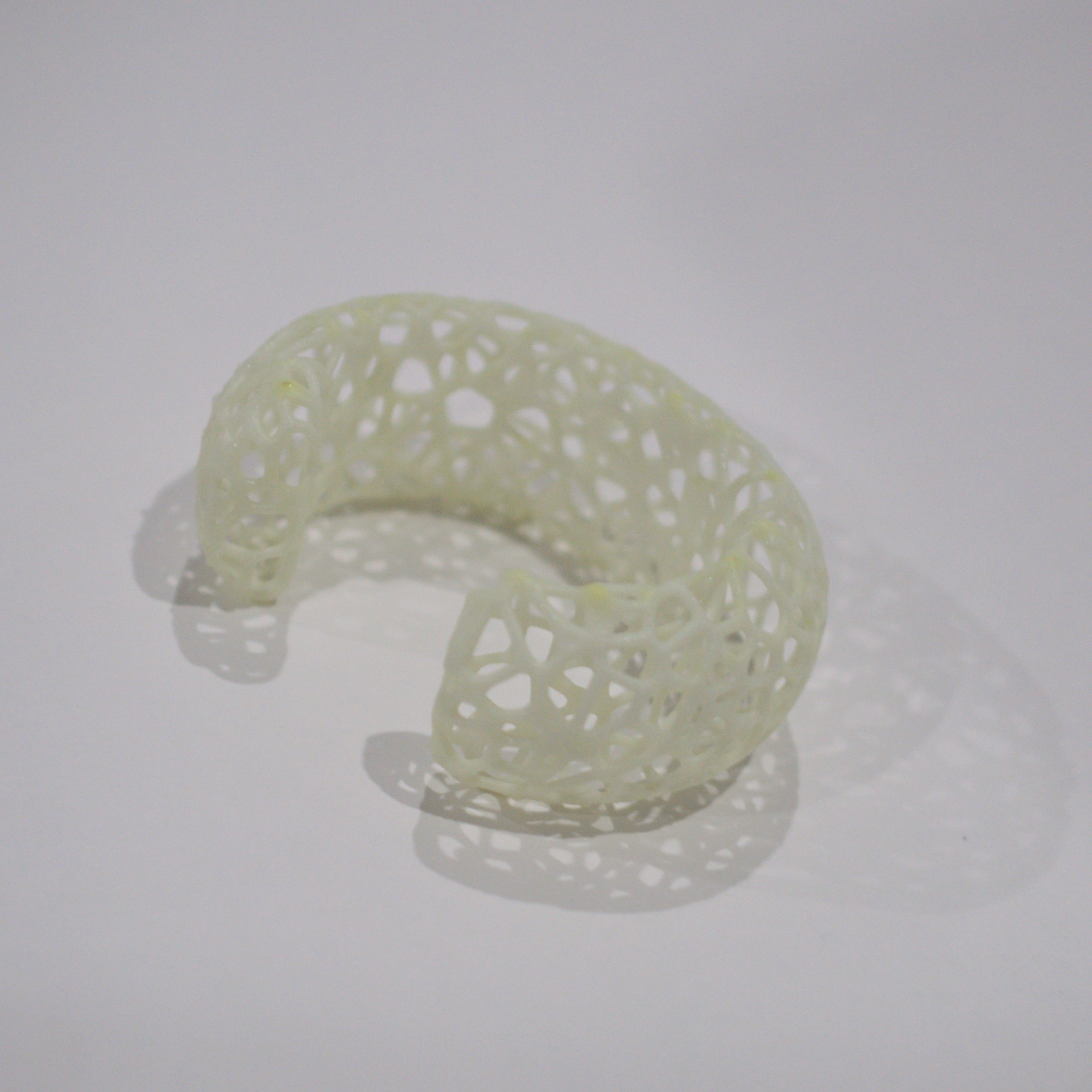 A cuff bracelet with intricate design on a light gray background