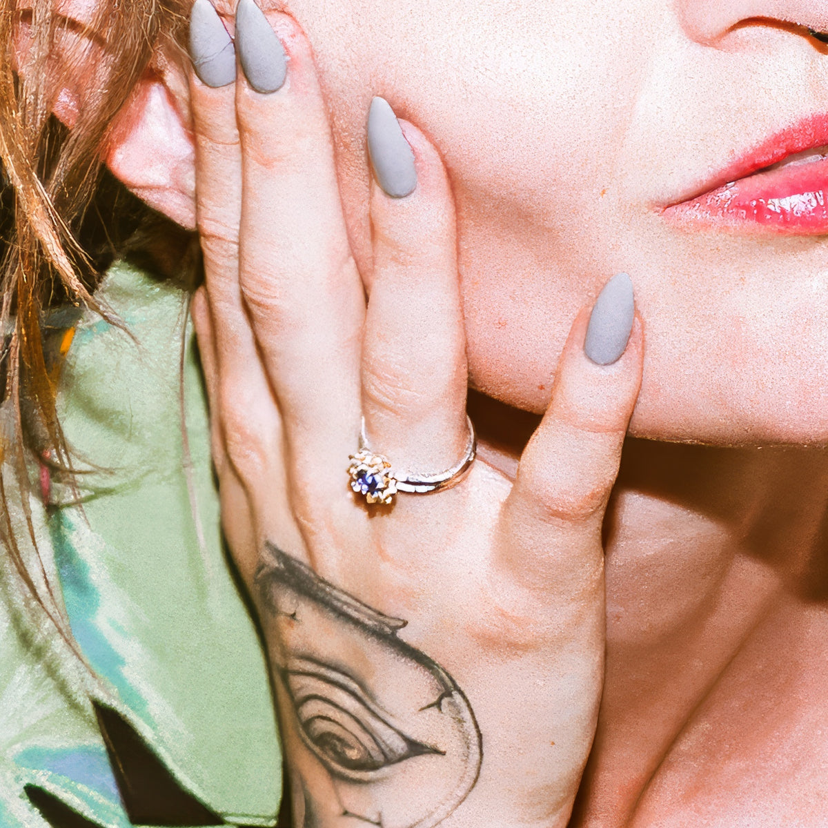 Lotus Engagement Ring with a blue sapphire, worn on a model's hand
