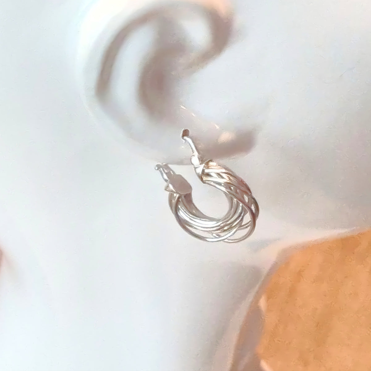 Silver Orbit hoop earring on a mannequin, side view