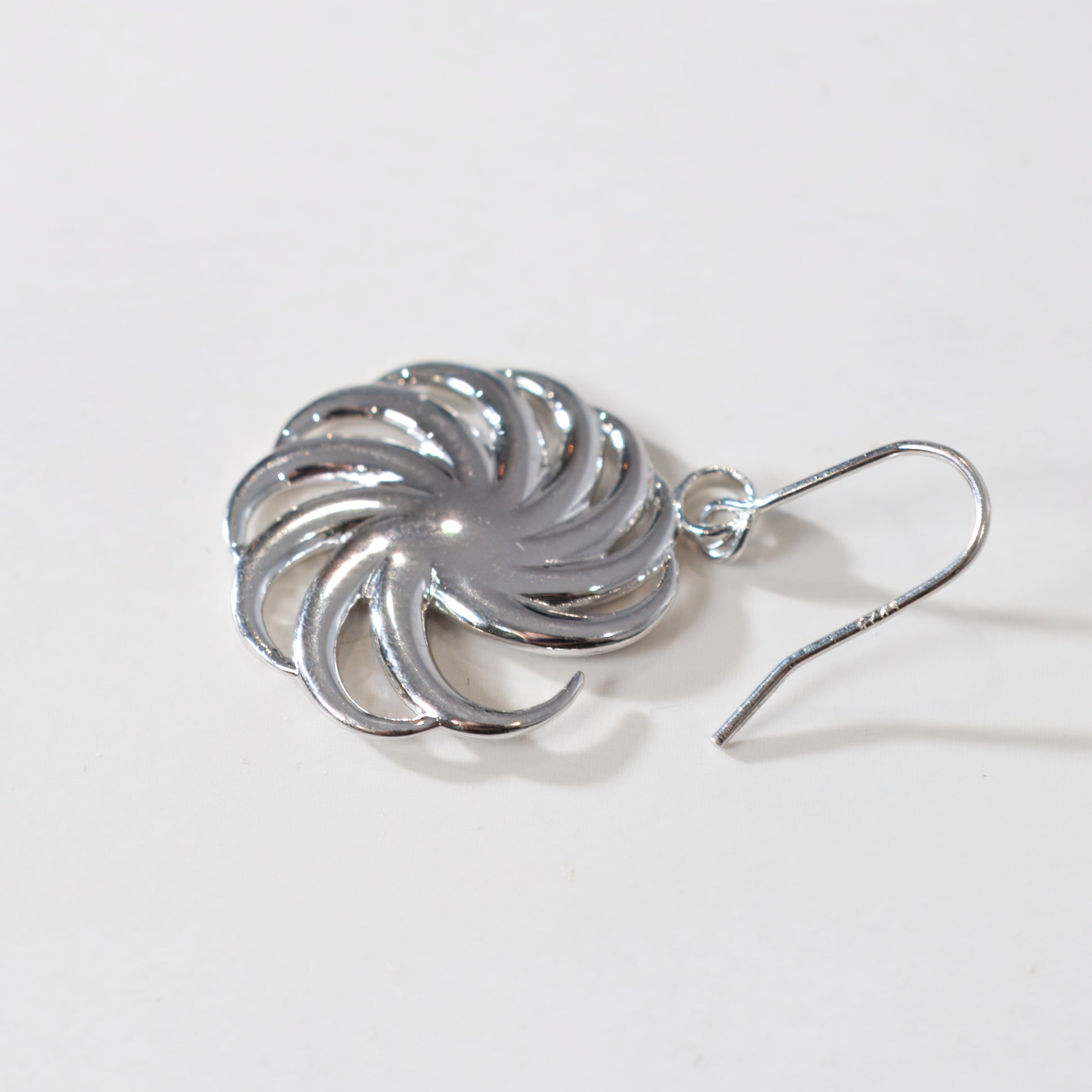 Silver spiral earring on a white background