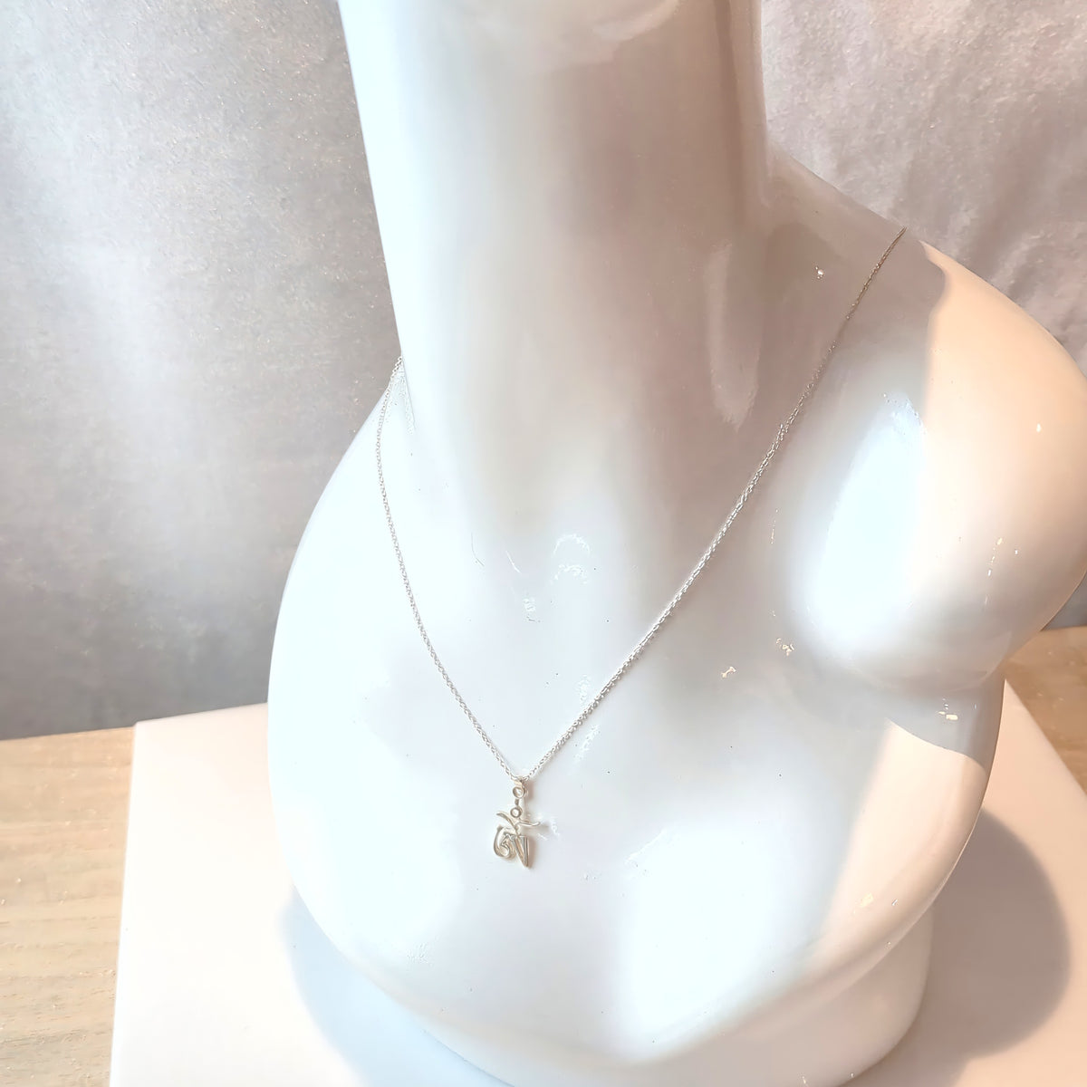 Silver Tibetan Om pendant on a white mannequin