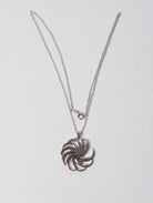 silver spiral pendant with chain showing clasp on white background