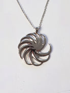 A round sterling-silver spiral pendant on a silver chain
