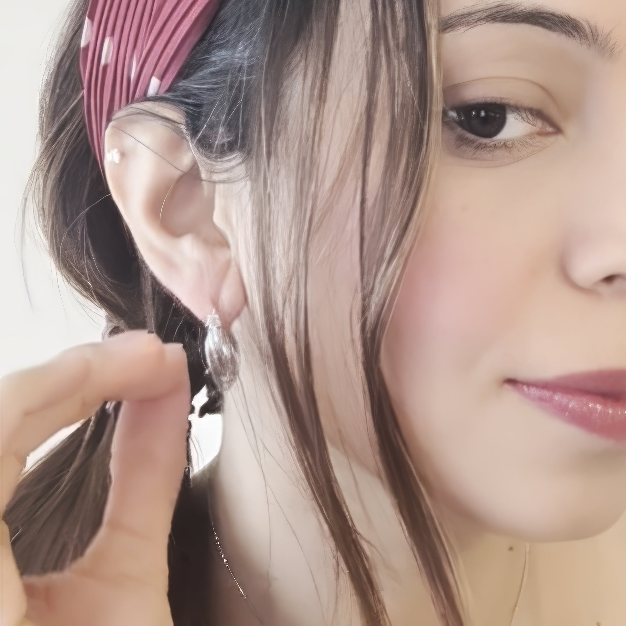 close of up silver orbit hoop earrings from frront of woman