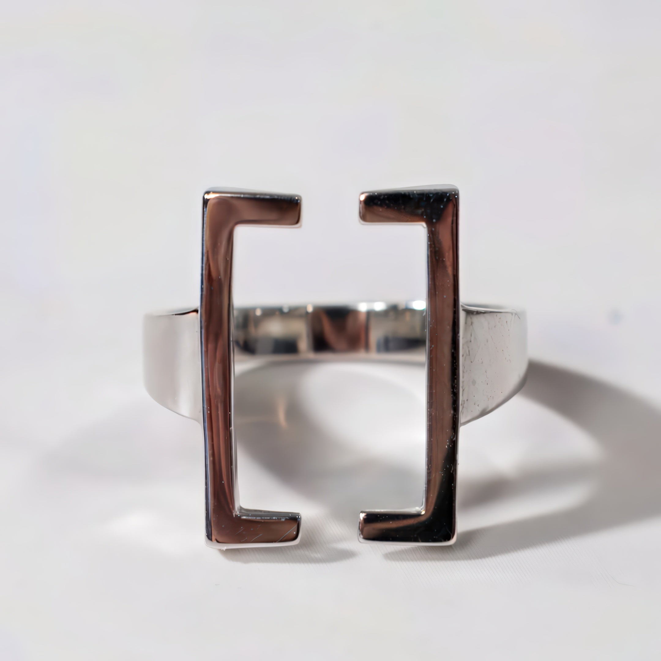 Silver ring with square design on a white background