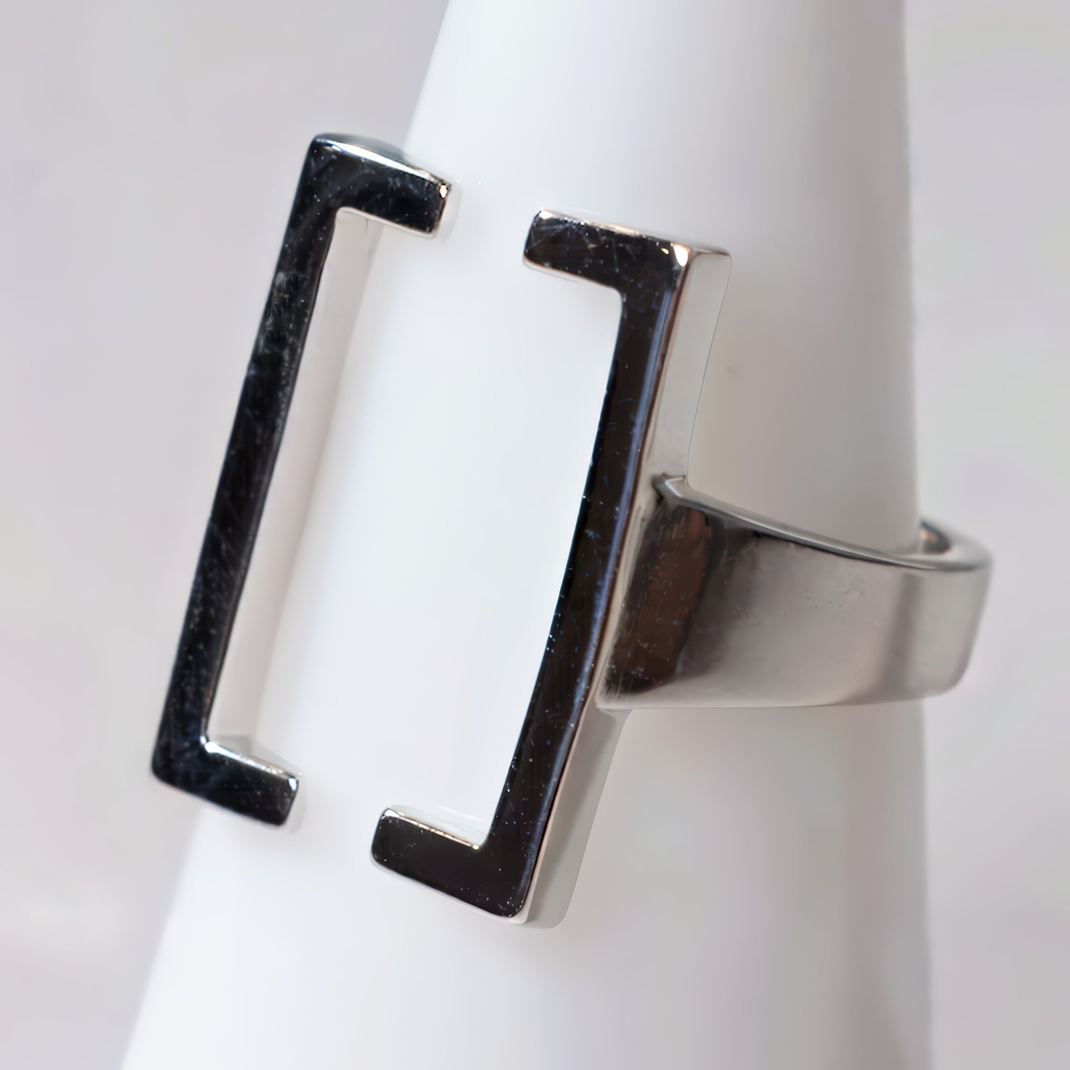 Silver ring with a unique design on a white background