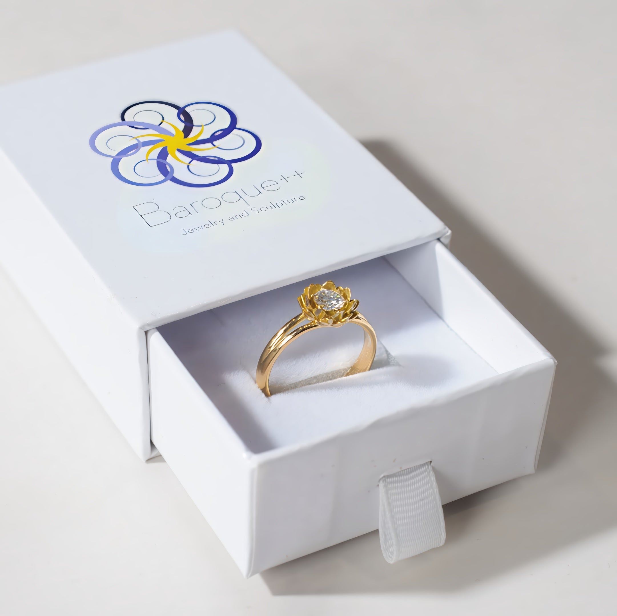 Gold ring with diamond in a 'Baroque' jewelry box on a light background