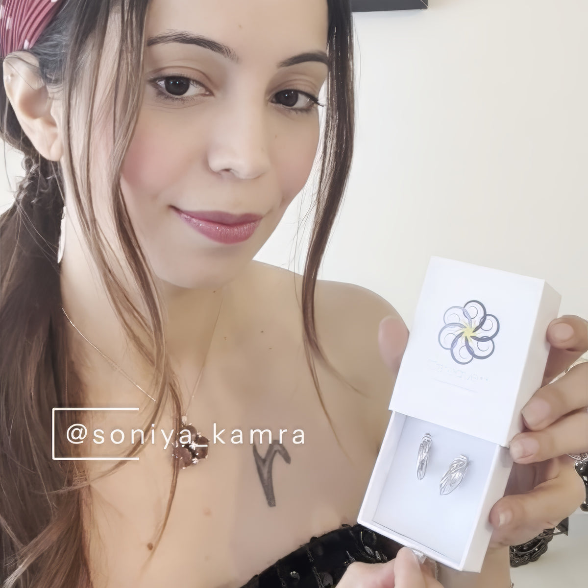 Woman holding a Baroque++ box of Orbit hoop earrings