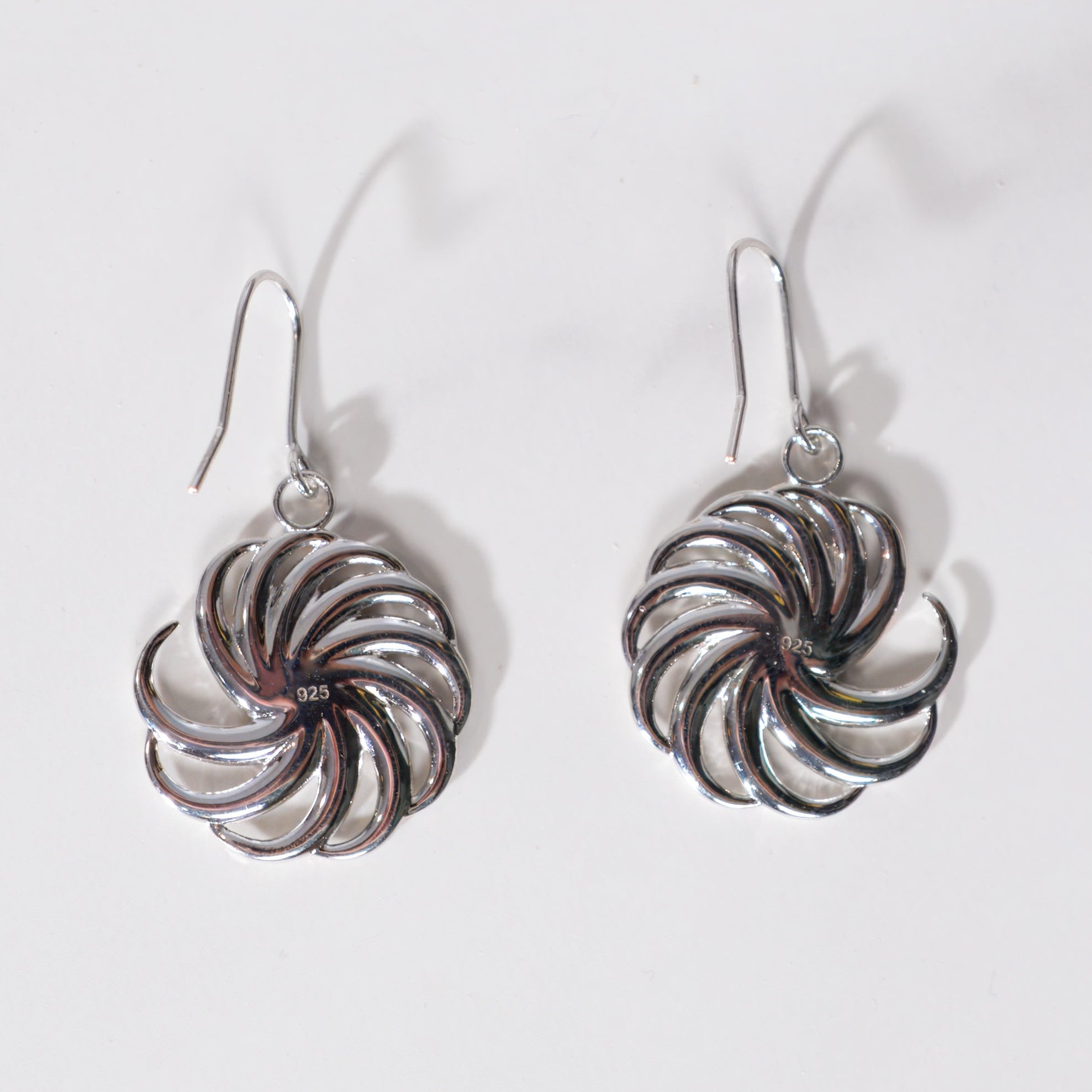 Pair of silver spiral earrings on a light gray background