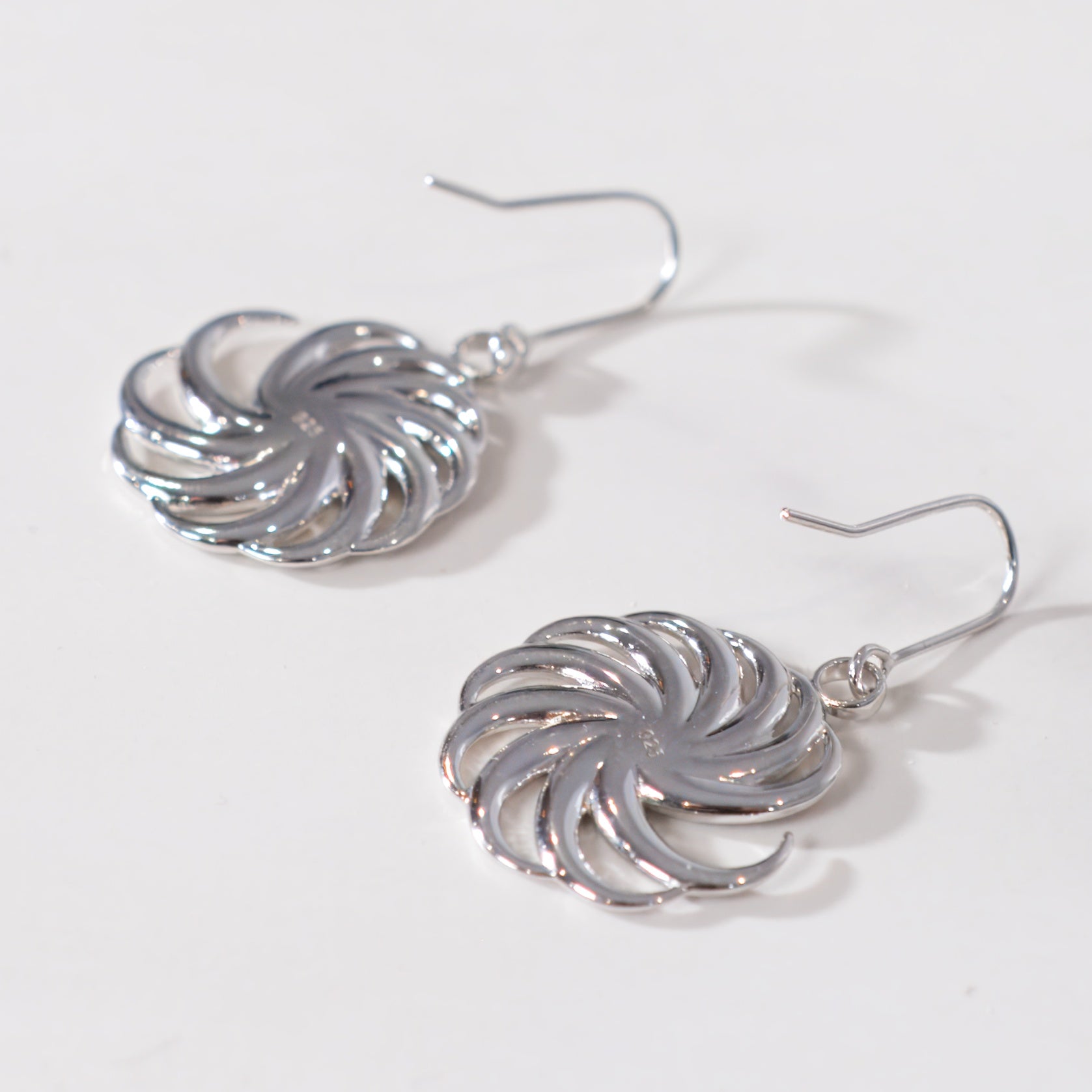 Silver spiral earrings on a white background