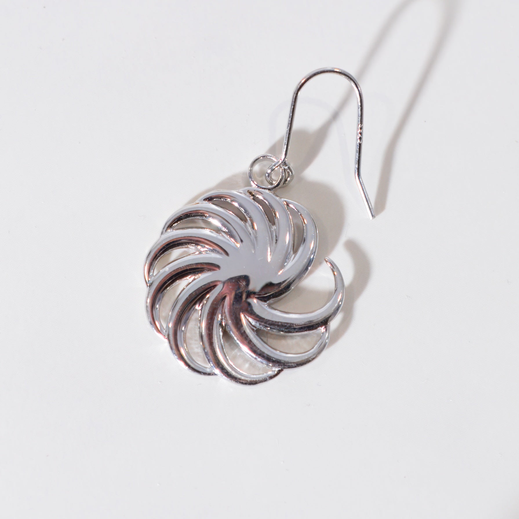 Silver spiral earring on a light gray background