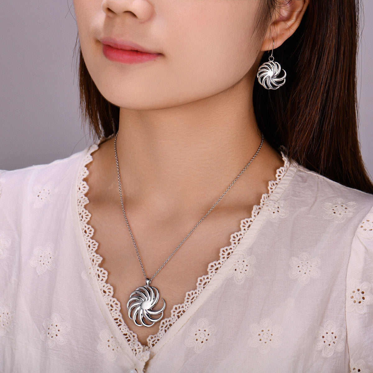 Model wearing the silver Spiral necklace and earrings set